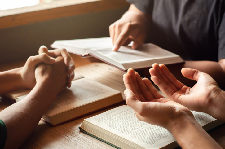 Christians join a group of cells that come together to pray, praise, and seek blessings from God. with the bible and friends sit and read the bible gospel sharing with copy space