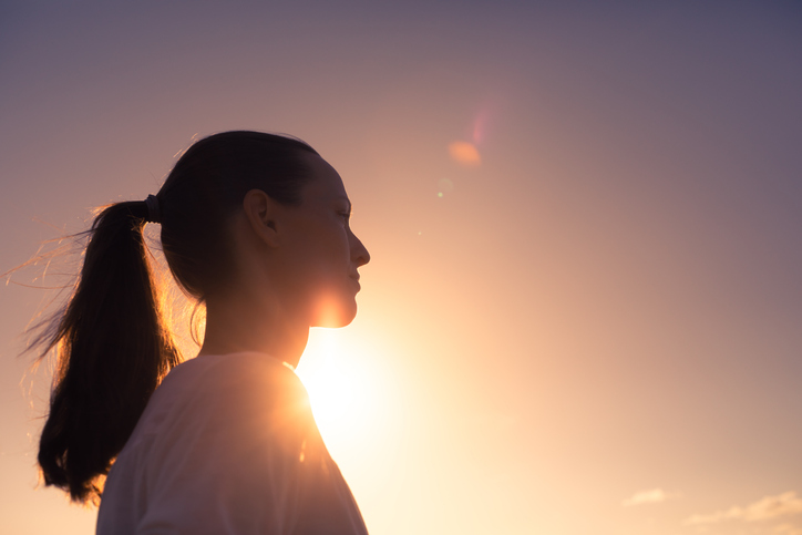 Looking in to the future. Woman thinking at sunset.