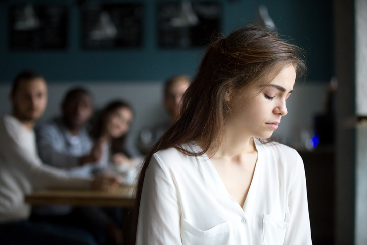 Sad young woman avoiding friends suffering from gossiping or bullying