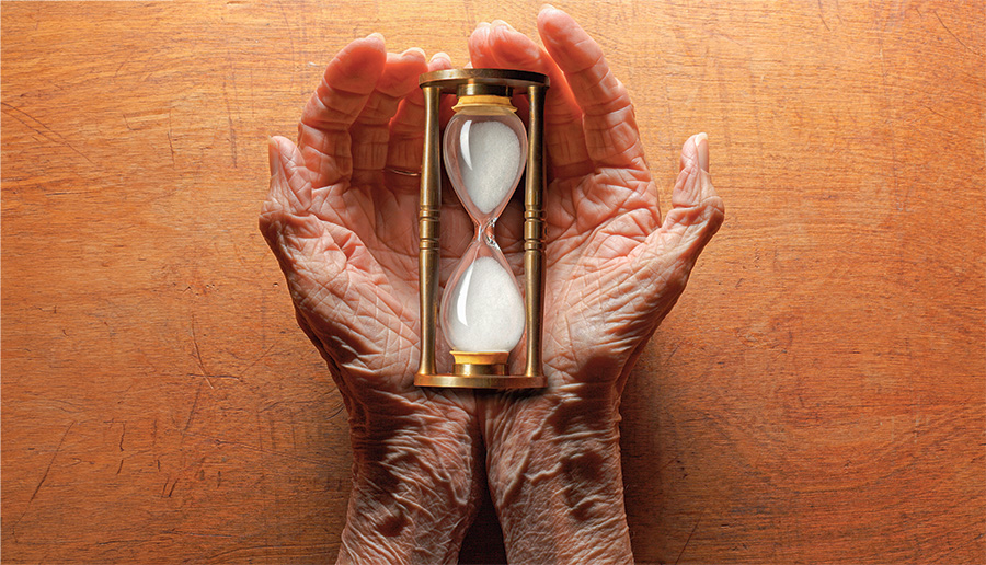Aging Woman’s Hands Holding Hourglass