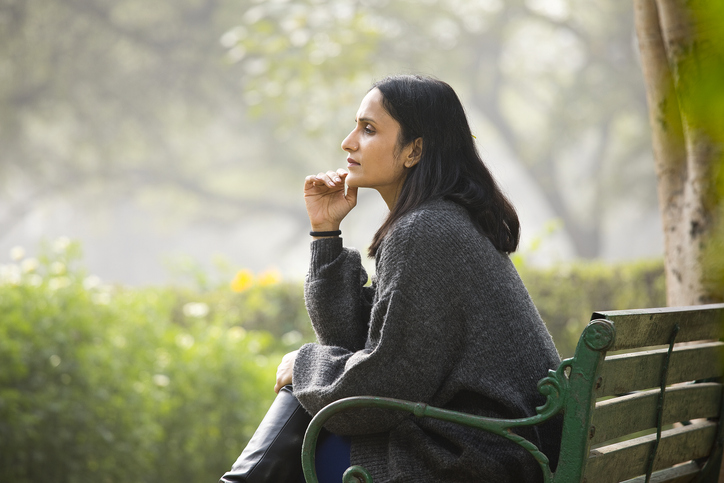 Thoughtful woman sitting on bench