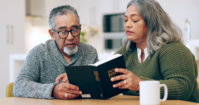 Reading book, old couple or bible in home for faith, religion or God with hope for worship in house. Studying Jesus Christ, holy spirit or Christian people learning literature or spiritual prayer