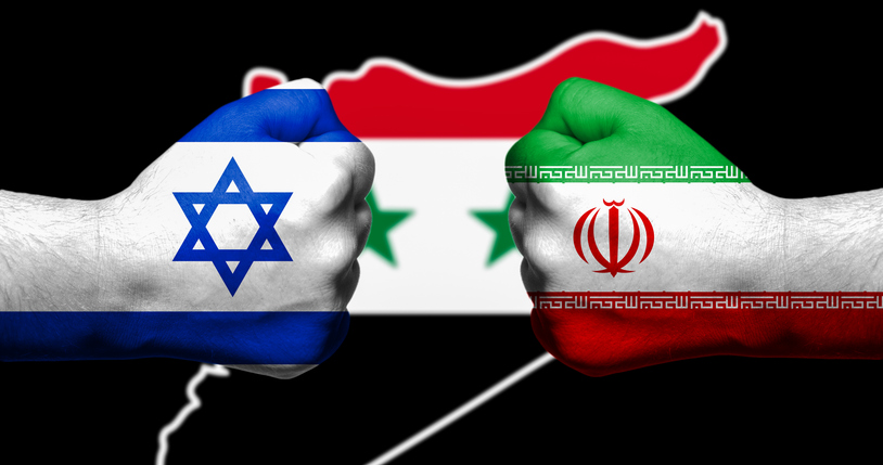 Flags of Israel and Iran painted on two clenched fists facing each other with map of Syriain the background/Israel &#8211; Iran conflict concept