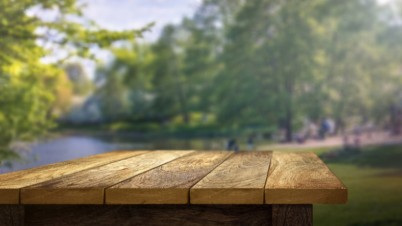 Empty wooden table with out of focus outdoor background