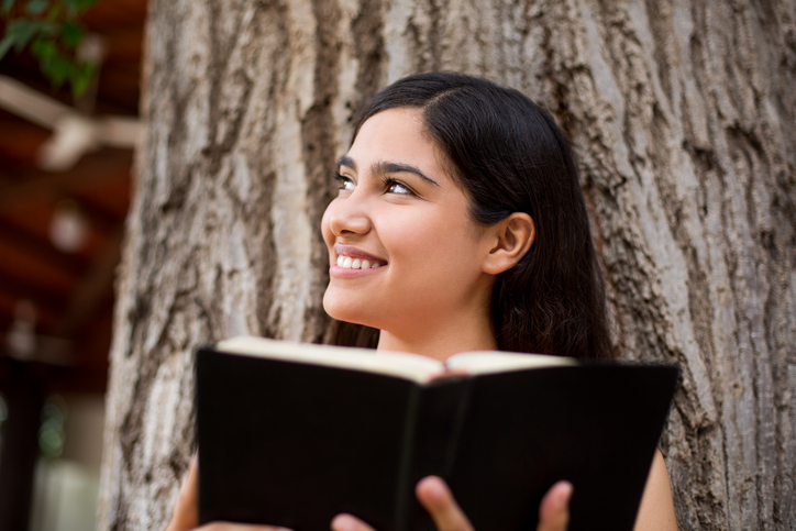 Beautiful young lady with Bible in hands