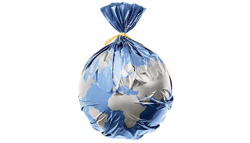 Globe of the earth in a plastic black bag like trash on white background