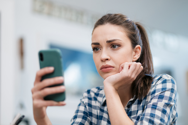 Close up of a sad young Caucasian woman reading bad news