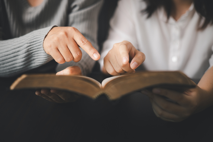 In the church, people to read Bible together, strengthening their faith as devout Catholics united by teachings of holy book. Christians are congregants join hands to pray and seek blessings of God.