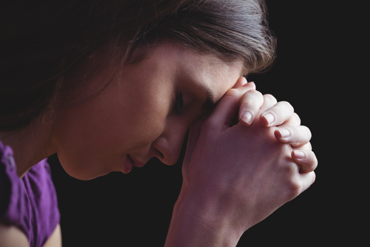 Woman praying with hands together