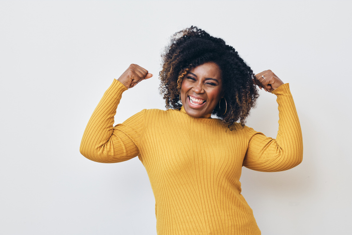 Cheerful strong woman flexing muscles against white background