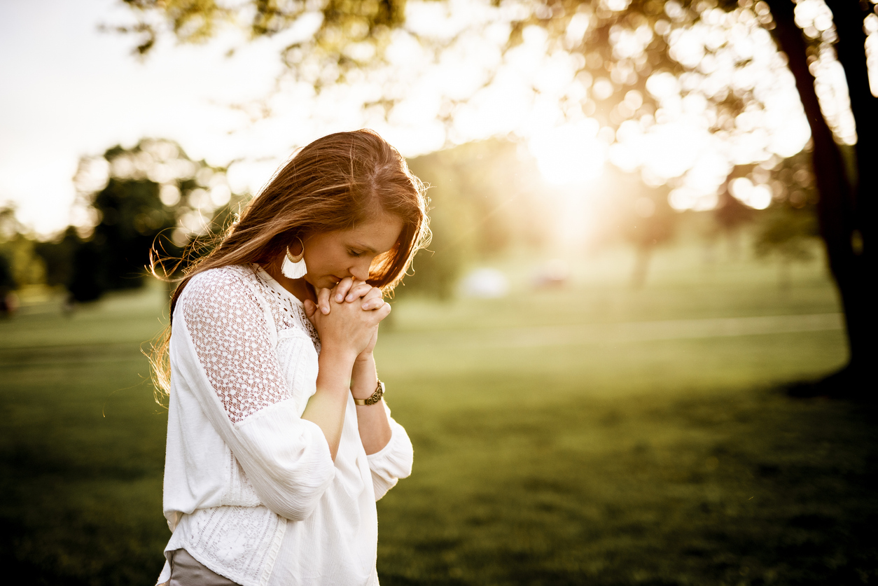 Closeup shot of a female praying with a blurred background