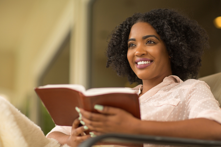 Woman smiling holding a book.