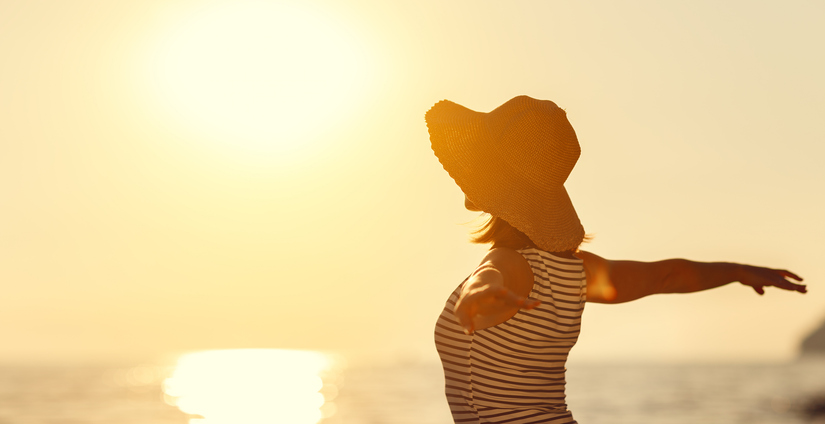 happy woman enjoying freedom with open hands on sea