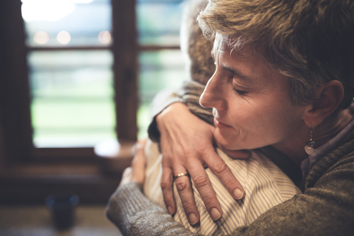 Senior couple embrace in kitchen