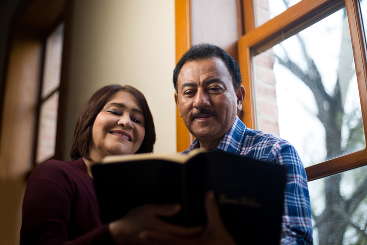 Smiling mature couple reading the Bible