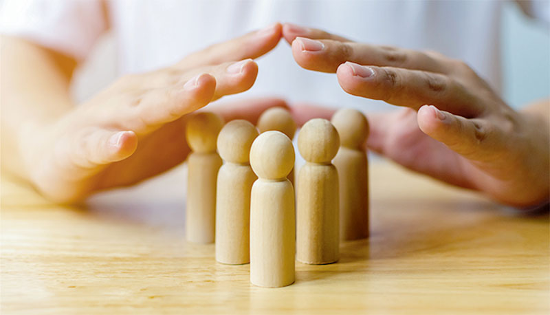 Protection people health and insurance concept. Hand shield protect wooden human on table