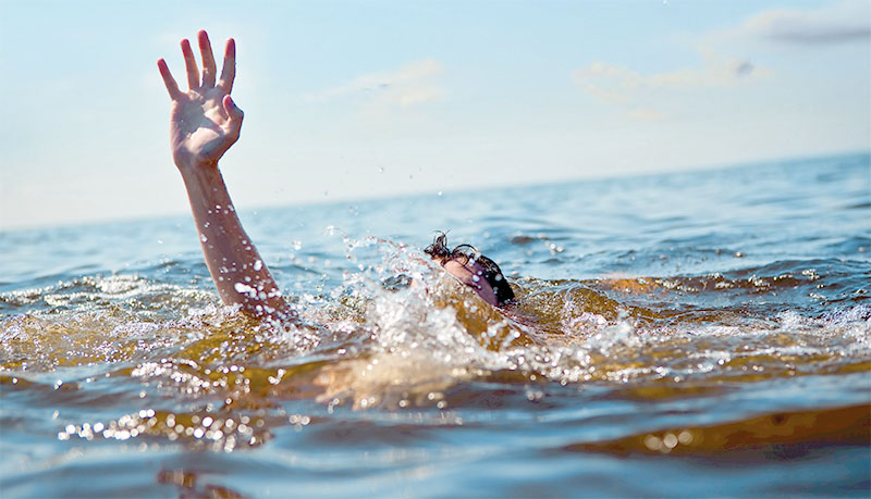 Person drowning in water with hand reached out