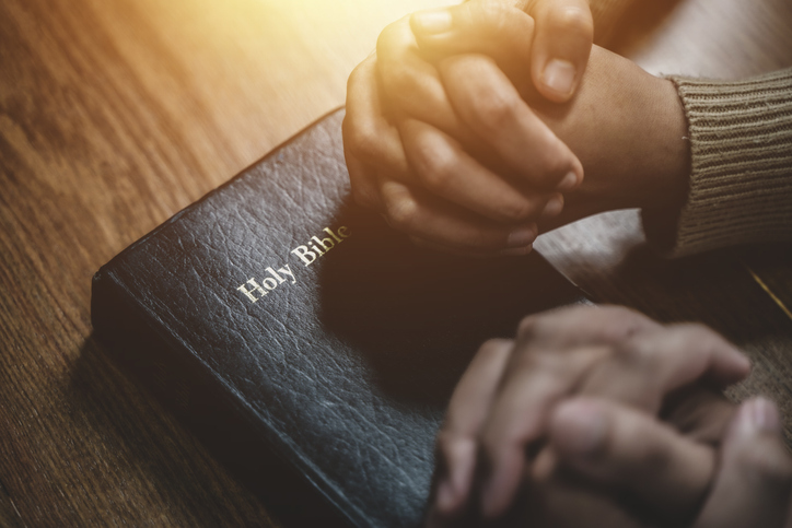 christian and prayer Group of christians holding hands praying together to believe and bible on wooden table for prayer meeting.