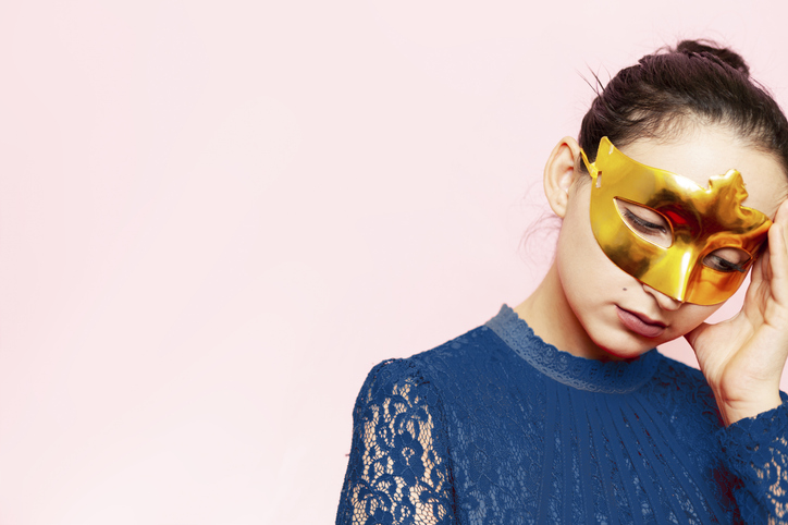 Portrait of beautiful woman in evening dress and golden masquerade mask. Valentines day, Carnival, Festive Ball, Birthday celebration concept. Facial expressions of young female