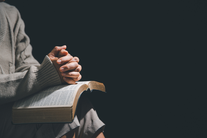 Christian life crisis prayer to god. Woman pray for god blessing to wishing have a better life. Female hands praying to god with the bible. begging for forgiveness and believe in goodness.