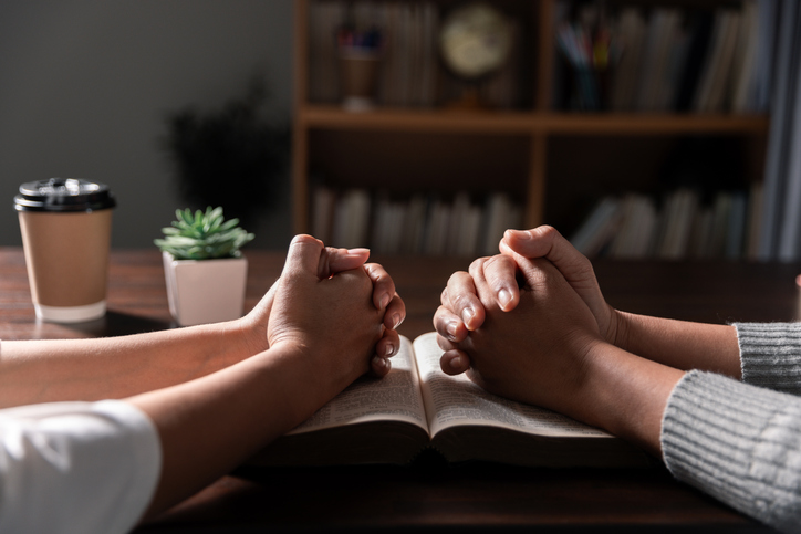 Group of different women praying together, Christians and Bible study concept.