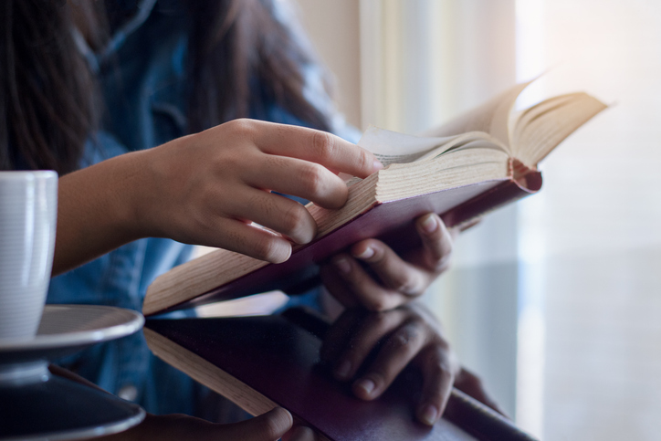 woman reading book at home