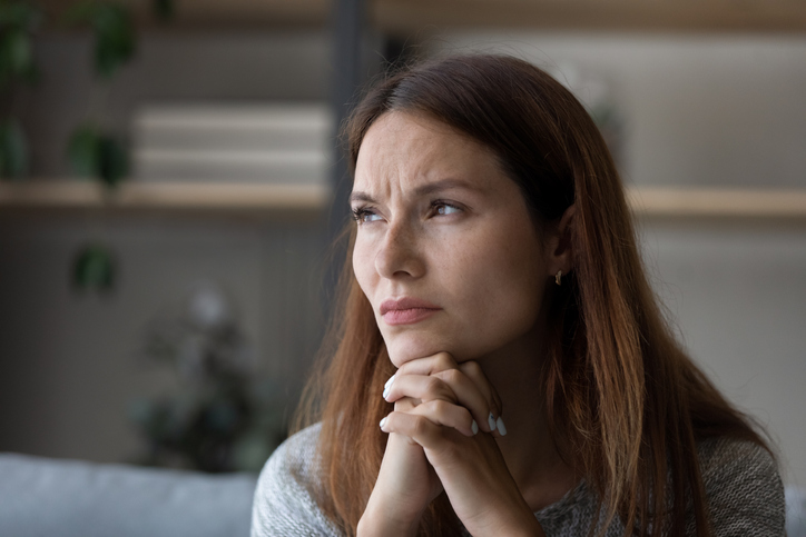 Anxious young woman look in distance pondering of problems
