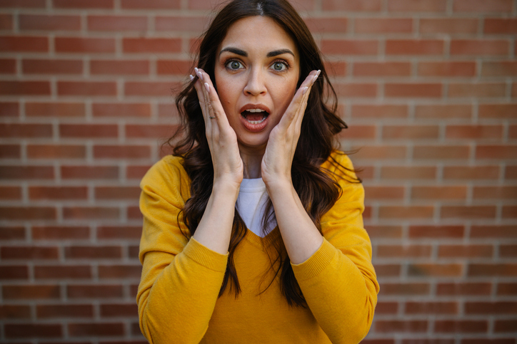 A surprised woman with hands on her face