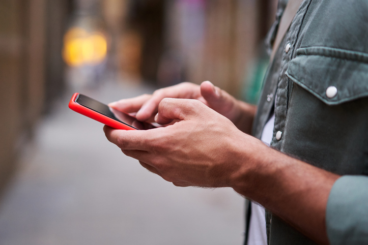 Close up of hands of an unrecognizable white man using phone to be connected one social media apps.