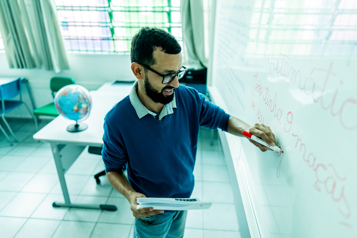 Teacher writing on the whiteboard in a classroom
