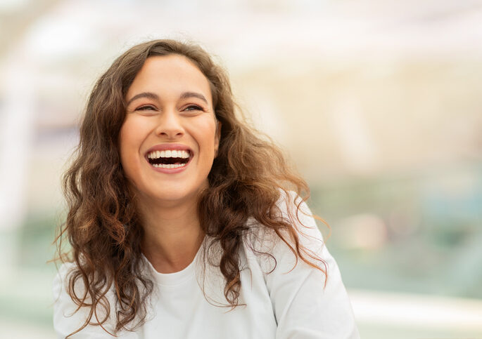 Closeup shot of beautiful young woman happily laughing