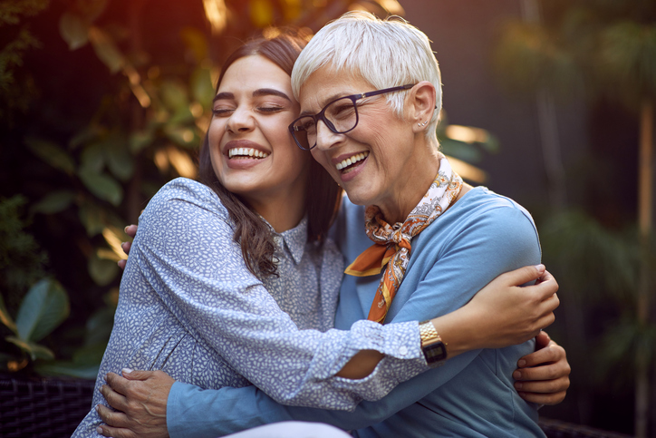 Daughter embracing her smiling mother.