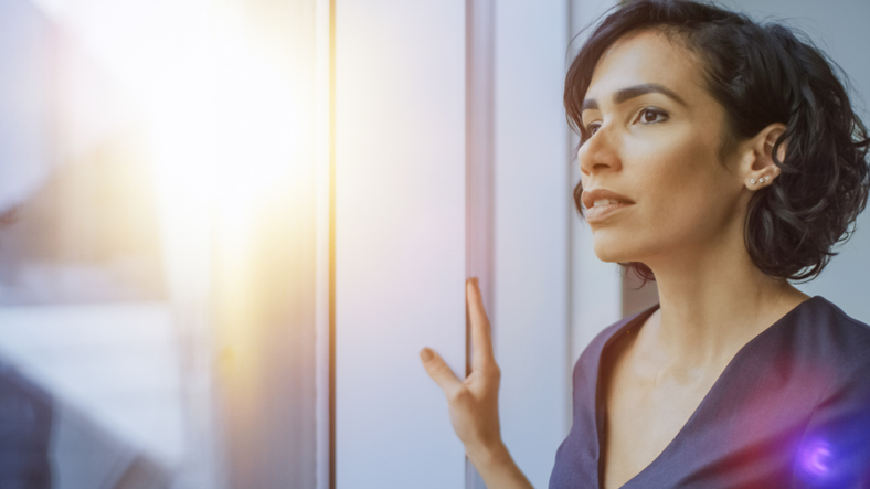 Portrait of the Beautiful Young Businesswoman Looking Thoughtfully out of Her Office Window. Confident and Attractive Hispanic Woman Thinking about Her Business Project.