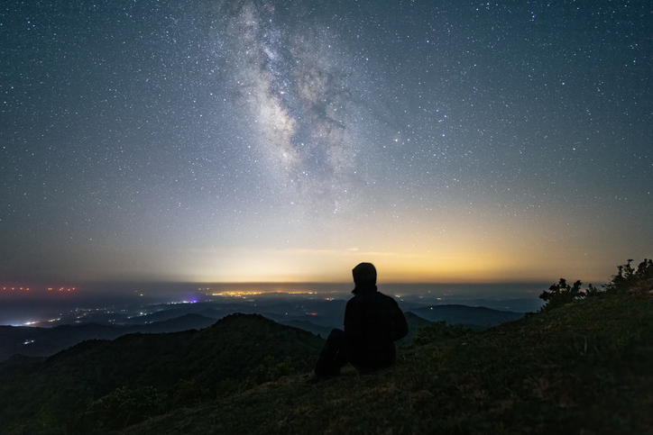 A Person Sitting and Admiring the Starry Night Sky with Milky Way