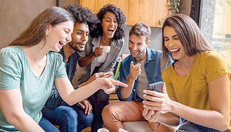 Happy group of friends at a cafe and talking on a video call