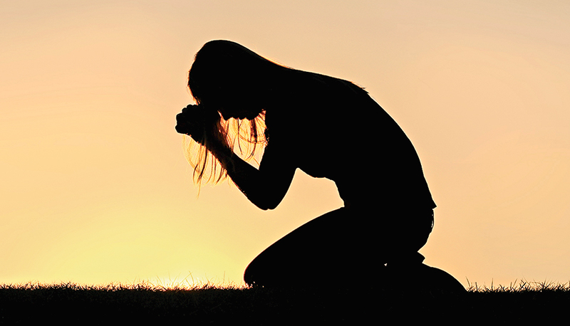 Christian Woman Sitting Down in Prayer Silhouette