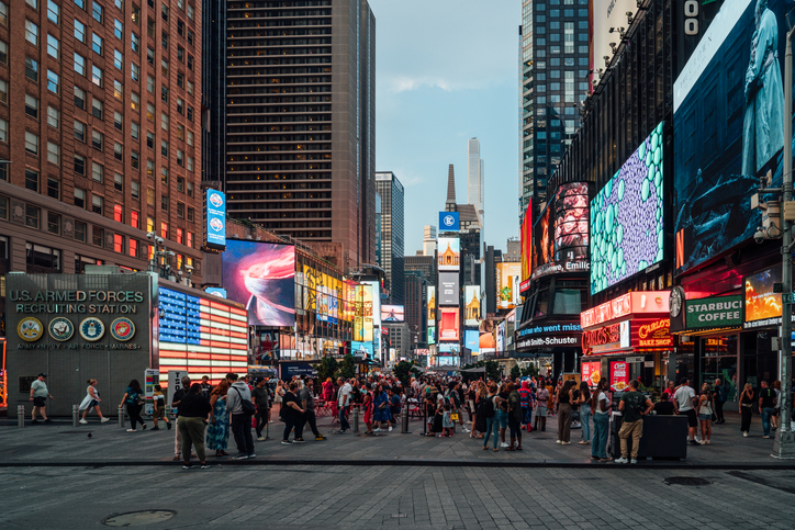 Tourists enjoying the evening lights of times square in new york city