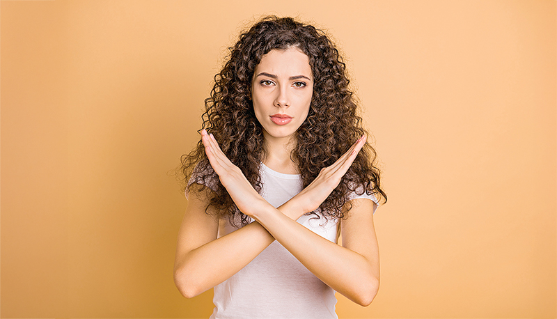 Photo of trendy serious brunette casual confident girlfriend showing you hands crossed restricting your access isolated over beige pastel color background