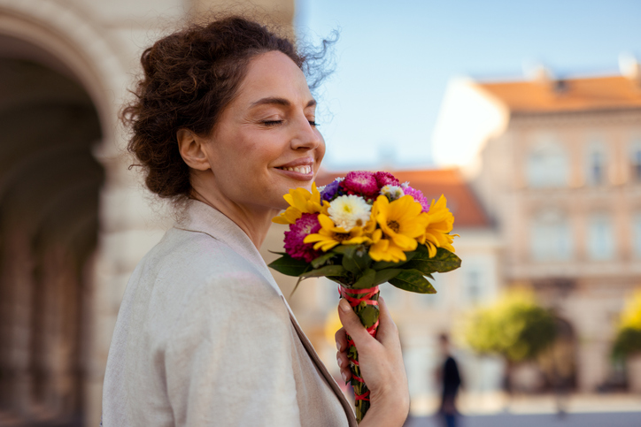 Mature Happy Woman With a Bouquet of Flowers Outside
