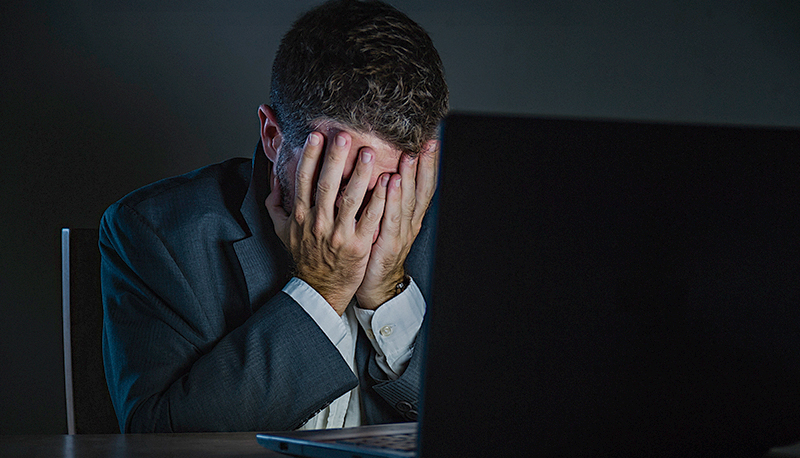 young desperate and stressed businessman working overtime at office laptop computer desk feeling anxious and overwhelmed suffering depression problem and anxiety crisis in business problem