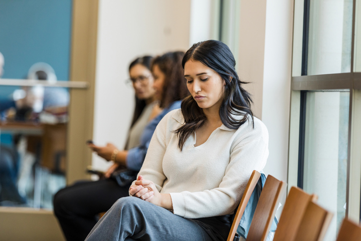 Young Woman Sitting Pensively in Waiting Room