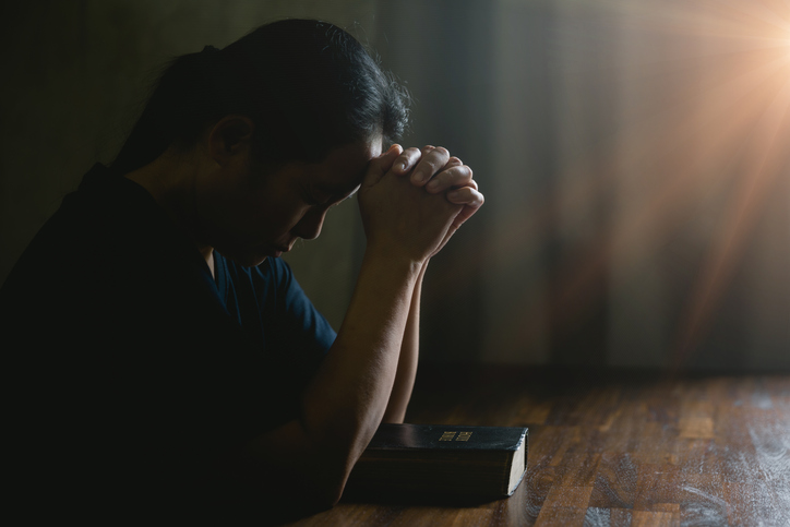 Prayer person hand in black background. Christian catholic woman are praying to god in dark at church. Girl believe and faith in jesus christ. Christ religion and christianity worship or pray concept.