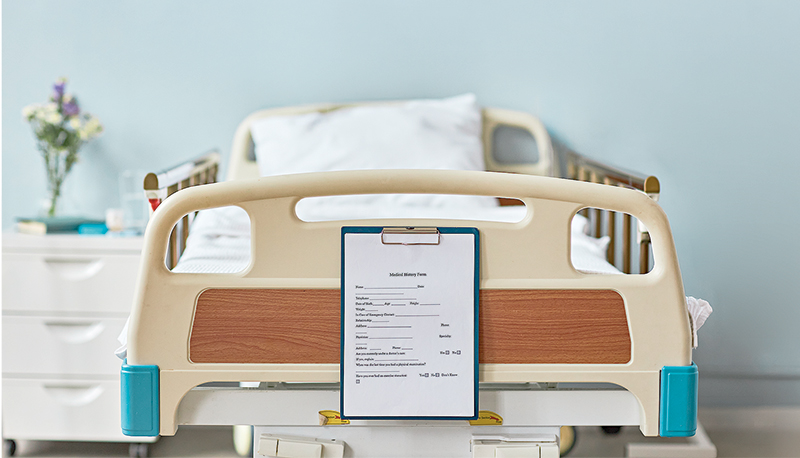 Background image of hospital room with focus on medical chart at bed