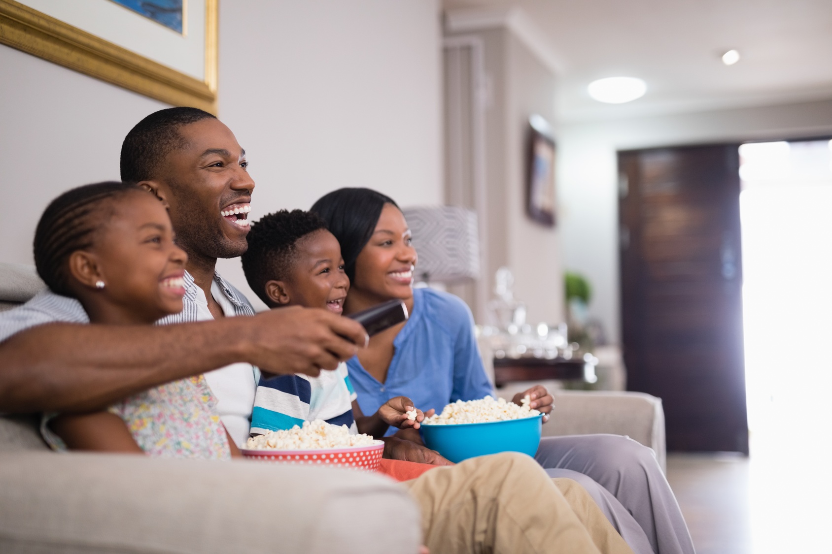 Cheerful family having popcorn while watching television